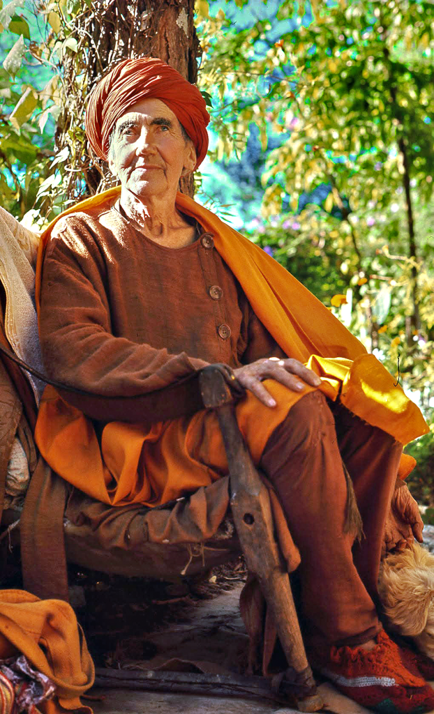 Sunyata, disciple of Ramana Maharshi, seated in Indian ochre robes under a tree.